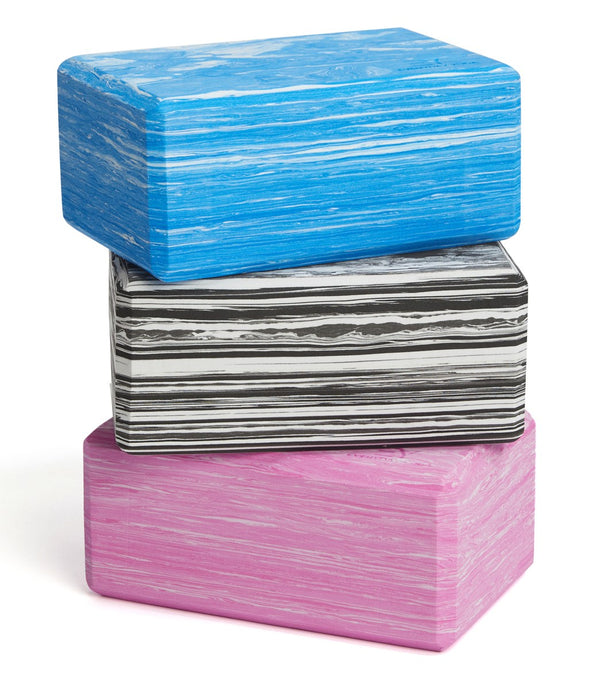 Everyday Yoga Foam Yoga Blocks in Wonderland Multi are shown in a stack, featuring vibrant blue, black, and pink colors with a marbled pattern. These durable blocks are perfect for enhancing stability and support during yoga practice. Ideal for both beginners and experienced