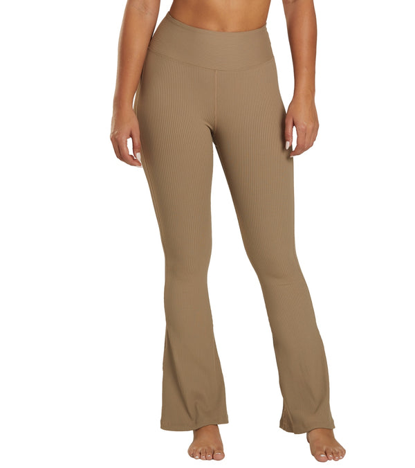 Year of Ours Women's Flare Yoga Pants in Caribou, designed for comfort and style during yoga sessions. These high-waisted, ribbed flare pants provide a flattering fit and flexibility for movement. Ideal for yoga enthusiasts seeking fashionable and functional active