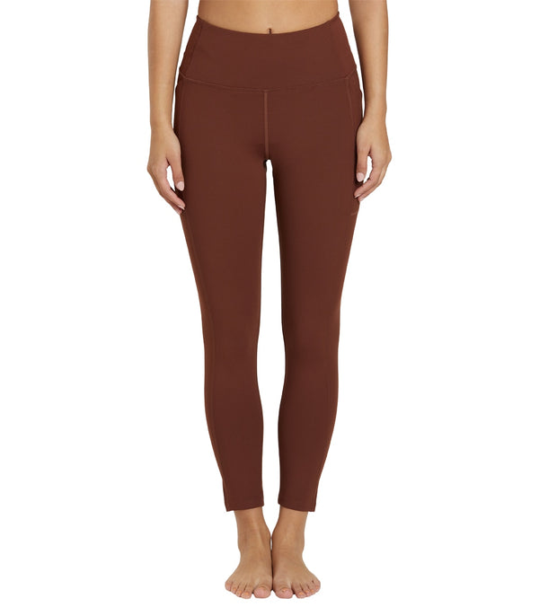 Girlfriend Collective Women's Yoga 7/8 Leggings in Earth color, designed for yoga and active wear. These leggings feature a high waist and a cropped length, offering comfort and flexibility for various movements. Ideal for sustainable fashion enthusiasts seeking eco-friendly yoga