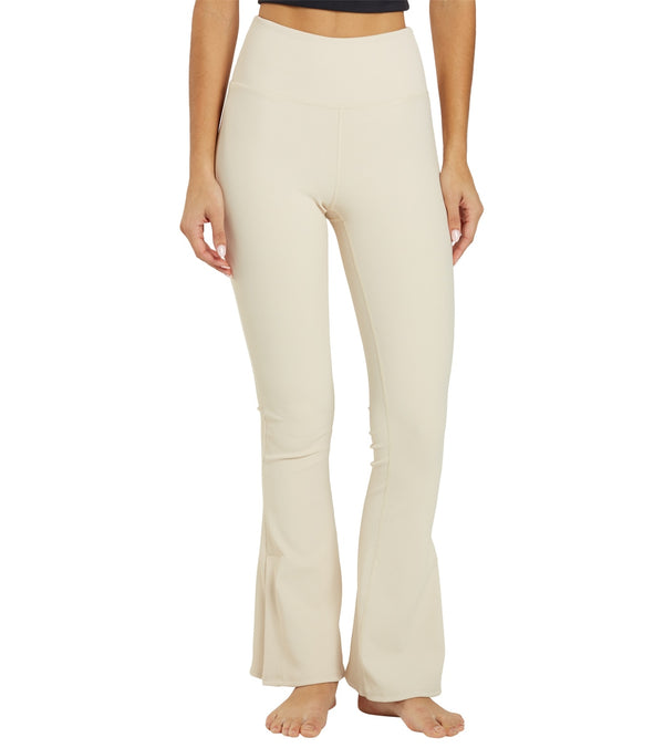 Thrive Societe Women's Flare Yoga Pants in Oatmeal, designed for comfort and style during yoga sessions. These high-waisted, flared pants offer a flattering fit and flexibility. Ideal for enhancing your yoga practice with a chic and functional look